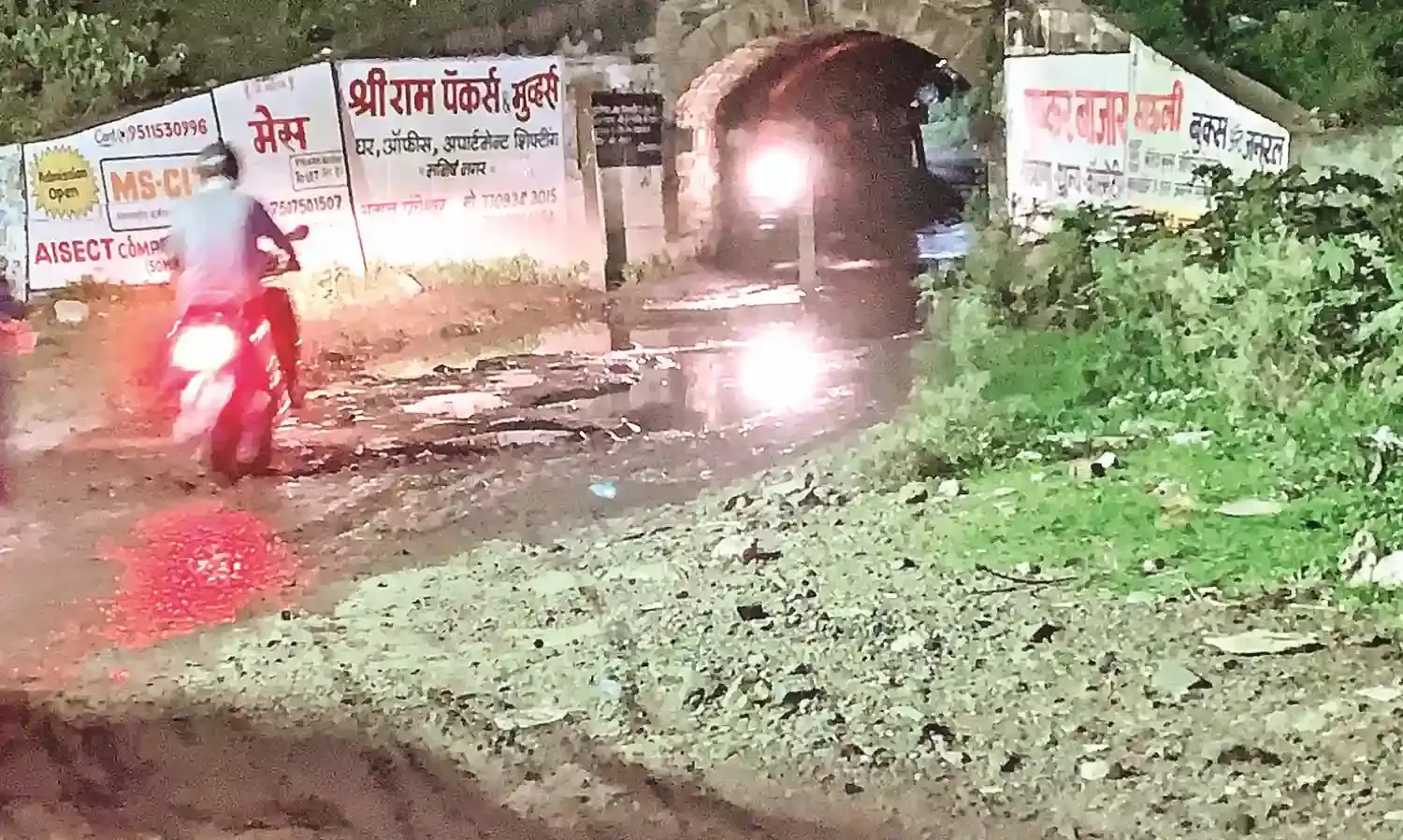 पथरीली सड़क और गड्ढों के कारण गिर रहे लोग