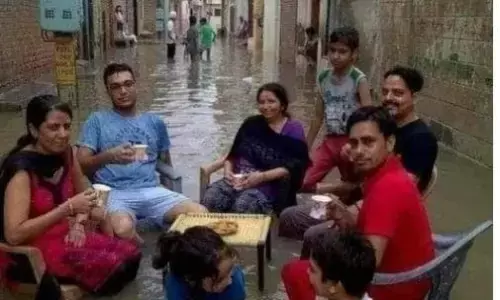 जलभराव के बीच कुर्सी में बैठकर चाय पीते लोगों की तस्वीर को फिर गलत दावों के साथ किया जा रहा वायरल, जानिए क्या है सच्चाई?