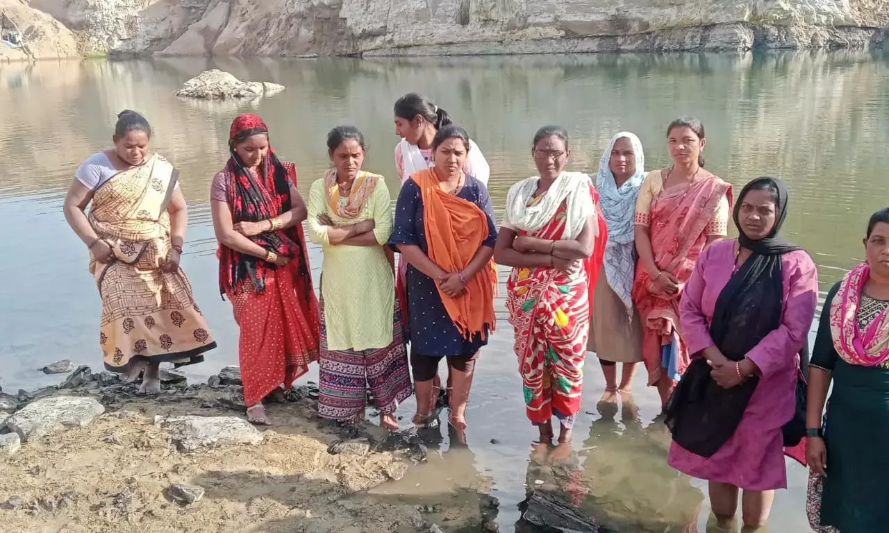 जमीन का मुआवजा मांगने के लिए महिलाओं ने गड्ढे में उतरकर दी जलसमाधि की चेतावनी