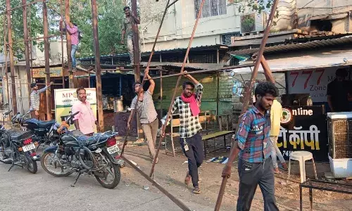 होर्डिंग पर टंगे कर्मी, स्ट्रक्चर का हिस्सा खोलकर ले गए