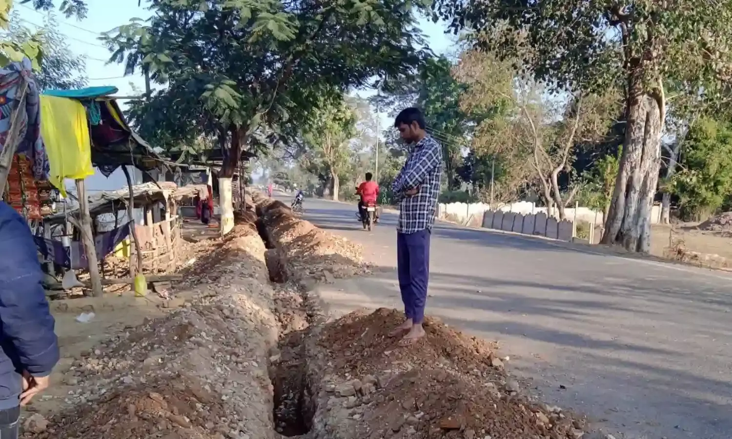 नव निर्मित सडक के शोल्डर खोदकर डाली जा रही पाइप लाइन, पीडब्लूडी ने बंद कराया काम, कोतवाली में दी शिकायत