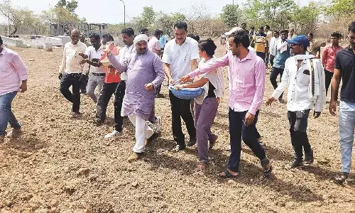 गुस्साए किसानों ने भेल की जमीन पर ट्रैक्टर से कर दी धान की बुआई