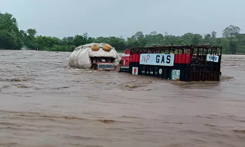 नदी में समाया ट्रक, बाढ़ में बह गए सिलेंडर,